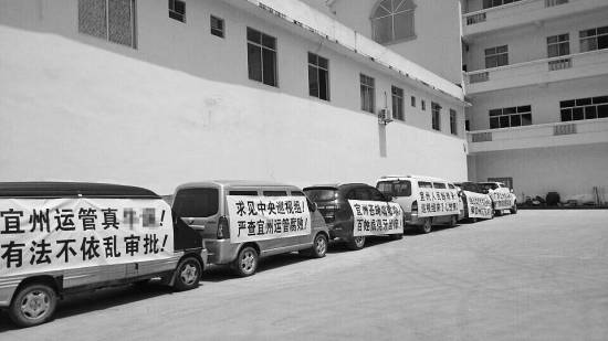 今年7月，宜州市運(yùn)管局通過了當(dāng)?shù)亓硪患臆嚈z企業(yè)開展?fàn)I運(yùn)車輛綜檢業(yè)務(wù)的備案，引發(fā)原來“獨(dú)家壟斷”河池綜檢市場(chǎng)的企業(yè)的不滿，其員工打出各種抗議標(biāo)語(yǔ)。 資料圖片